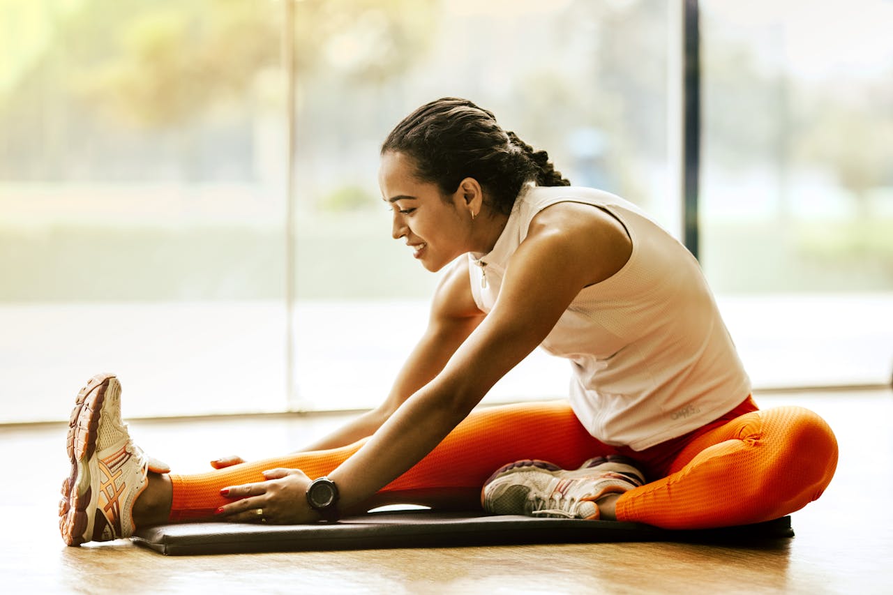 A woman enjoying a yoga stretch indoors, promoting a healthy lifestyle.